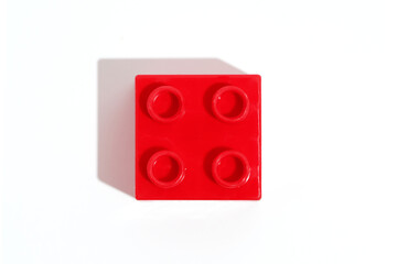 Top view square red plastic block brick toy for building constructions on white isolated background. Concept detail for an educational game. Image for your design