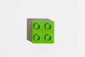 Green square plastic building block toy for constructor on white isolated background. The concept of children's educational games. Image for your design