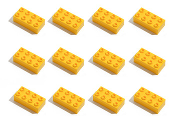 Pattern of many rectangular yellow plastic building block bricks toy for constructor on white isolated background. The concept of educational games. Image for your design