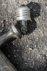 Broken light bulb lying on ground with hammer, closeup photo, Damaged incandescent light bulb with...