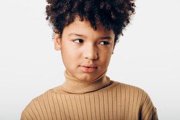 Young african american girl with afro hair gazing intently at the camera against a crisp white background