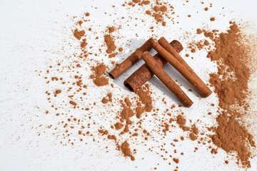 Cinnamon sticks and powder on a white background