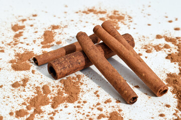 Cinnamon sticks and powder on a white background