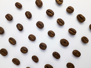 Roasted coffee beans arranged on a white background