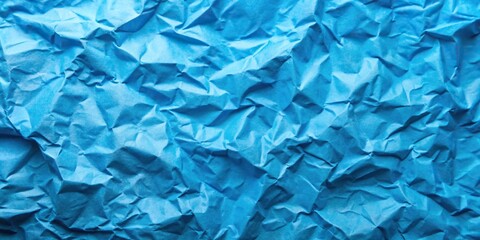 Obraz premium Bright blue crumpled paper texture background for design projects