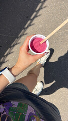 Female's hand holding a creamy pink ice cream