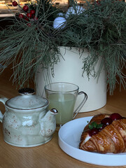 A tranquil morning scene featuring a steaming cup of tea, a buttery croissant, and tasteful elegant decor, autumn consept