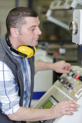 Obraz premium worker entering data in cnc machine at factory floor