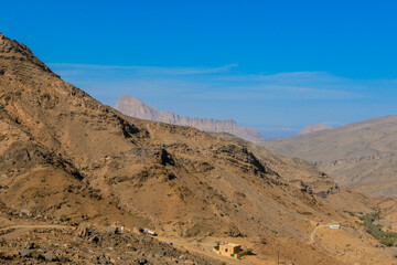 A breathtaking view of the rugged mountains and arid landscapes in Oman under a clear blue sky