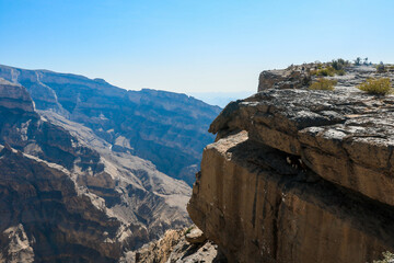 Exploring the breathtaking cliffs of Oman\'s mountainous landscape under clear skies