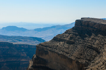 Exploring the rugged mountain landscapes of Oman under a clear blue sky during midday