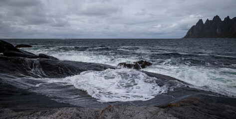 Ocean waves crushing on the rocky Tungeneset beach, Senja, Norway. Seasonal scenery of Scandinavia.