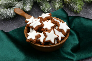 Zimtsterne traditionelles Weihnachtsgebäck in einer Keramikschale mit Tannenzweigen.