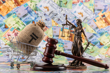 The figure of Themis and the judge’s gavel against the background of Kazakh tenge bills of various denominations