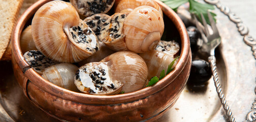 Bourgogne Escargot Snails with garlic oil in a metal plate.