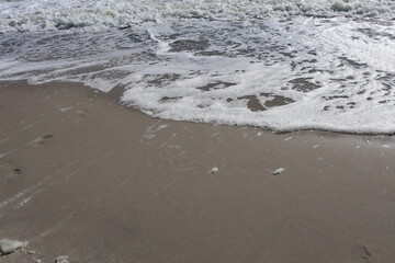 Foamy Ocean Waves Gently Reaching the Sandy Shore