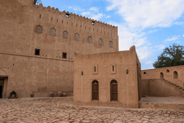 Fototapeta premium Explore the ancient forts of Oman showcasing unique architecture and cultural heritage in a serene landscape with blue skies