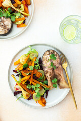 Baked silver carp with roasted carrots, zucchini, beets, and garlic, perfect for a healthy and delicious breakfast or lunch