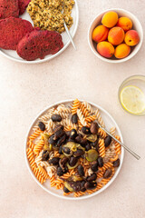 Gluten-free pasta with baked beans and zucchini, paired with beet pancakes topped with sunflower seed hummus. This healthy vegetarian meal is both delicious and nourishing