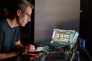 Video Director Managing Multiple Screens and Equipment in a Control Room During a Live Broadcast