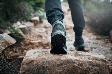 Hiking, shoes and rocks with person on mountain for explore, health and adventure. Challenge, wellness and holiday with closeup trekking in nature path for walking, fitness and camping vacation