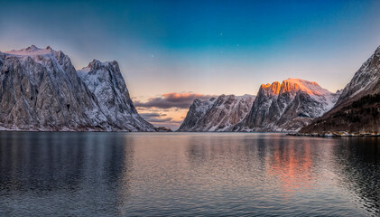 Bergpanorama auf dem Wasser bei Sonnenuntergang mit schneebedeckten Gipfeln