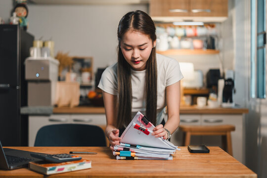Organized woman sorting through documents in modern office space, showcasing focus and productivity. scene reflects diligent work ethic and commitment to maintaining order