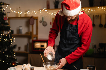 Man in Santa hat mixing Christmas cookie dough