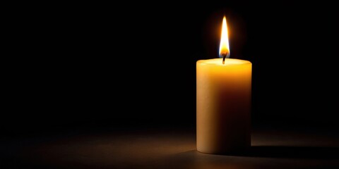 Candle flame burning brightly in dark background