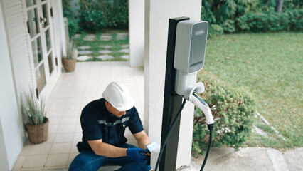 Qualified technician install home EV charging station, providing maintenance service for electric...
