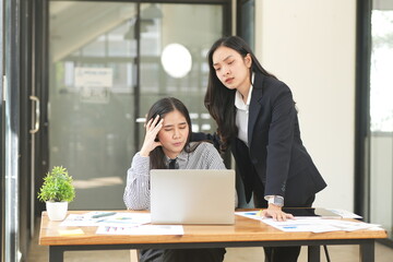 Asian woman stressed out working in the office