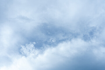 Fluffy white clouds drift across a vast expanse of blue sky
