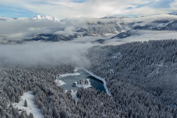 Famous Lake Cauma covered with snow in the cold winter atmosphere from above, Switzerland.