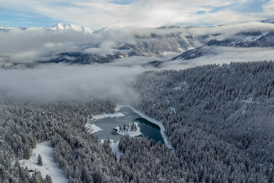 Famous Lake Cauma covered with snow in the cold winter atmosphere from above, Switzerland.
