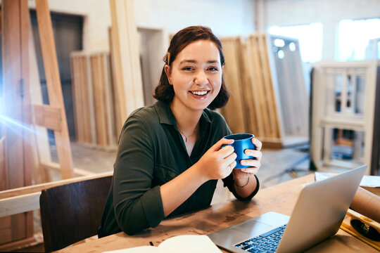 Coffee, laptop and portrait of carpenter woman at desk of office in warehouse for joinery or woodworking. Computer, craftsmanship and design with happy artisan in industrial plant for carpentry - Powered by Adobe