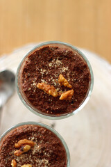 Two bowls of chia seed, chocolate and orange pudding. Healthy snack, wooden background. Top view.