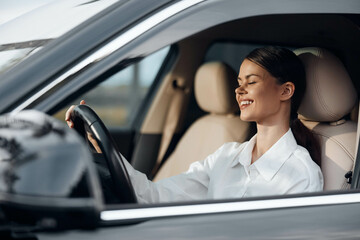 Woman, car, driver's seat, eyes closed, hands on steering wheel a woman sitting in the driver's...