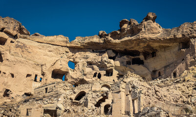 Exploring ancient rock cut churches and caves in Cappadocia under a clear blue sky