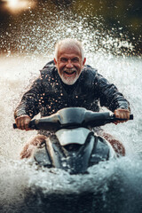 Senior male riding a jetski in water. Summer tropical sports.