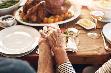 Hands, pray and food with a senior couple sitting at a dining room table for a roast lunch...