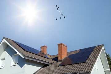 Obraz premium Modern House with Solar Panels and Flying Birds