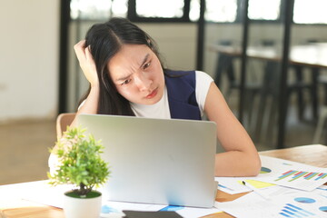 Asian woman stressed out working in the office