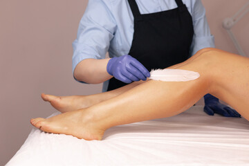 Aesthetic leg waxing process with gentle techniques in a tranquil beauty salon setting