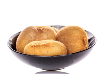 Several ripe juicy kiwis in a ceramic plate, macro, isolated on white background.