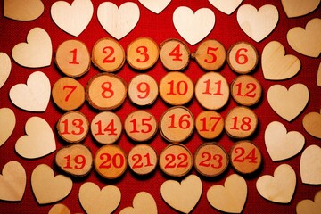 Wooden Christmas Advent, 1 to 24 Christmas countdown, surrounded by wood love hearts against a red stitch background. A gentle warm light illuminates the scene. 