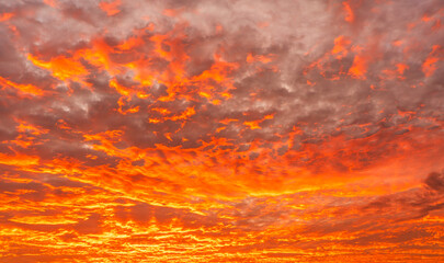 Fototapeta premium Dramatic red sky, Sunset fire sky with orange, yellow colorful sunlight reflected fluffy clouds in the evening after sun down, Dusk sky background 