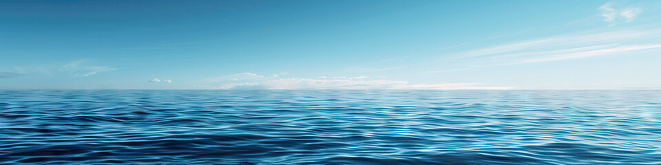 Obraz premium A calm blue sea, its surface dotted with small whitecaps under a clear sky.