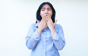 shocked asian woman covering her mouth wide open wearing striped shirt isolated on white background