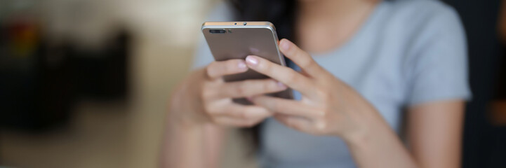 Asian teenage student woman using smartphone to chatting with friends and surfing social media...