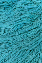 A blue shaggy hairy rug in closeup